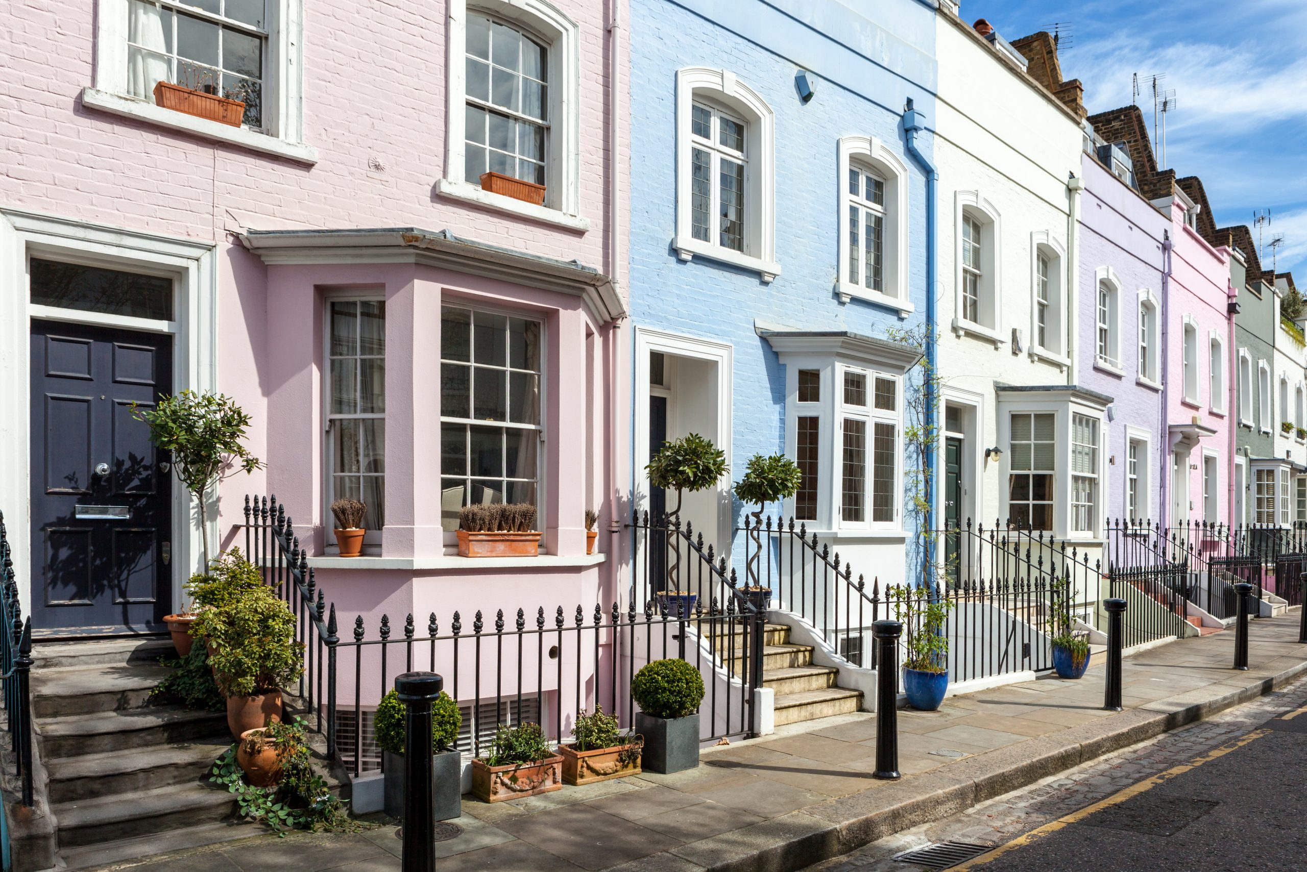 A row of colorful, charming townhouses in London, similar to those managed by Beacons Way Property Management.